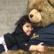Unity Shoppe little girl embracing a big teddy bear